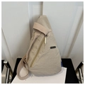 Detailed view of beige crossbody chest bag featuring a front zipper pocket and metal plate - Khaki