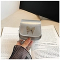 Silberne Mini-Umhängetasche mit Schmetterlingsschnalle und Kette auf altem Buch - Silber