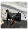 Detail of black glossy faux leather baguette bag featuring a silver star metal ornament - Black