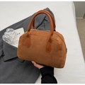 Macro detail of the brown suede Boston bag texture and leather top handles on a grey coat - Brown