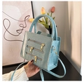 Detail van de lichtblauwe krokodillenstructuur en gouden ritsdetails op de handtas voor dames - Blauw