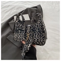 Close-up of leopard print hobo bag with gold hardware and adjustable strap on a blazer - Black