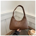 Gros plan détaillé sur la texture crocodile marron foncé d'un sac porté épaule vintage - Café