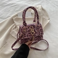 Handtasche mit pinkem Leopardenmuster, goldenem SS-Logo und Quasten auf beigem Sakko - Rosa