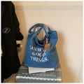 Detailansicht der blauen Denim-Tragetasche mit Buchstabendruck und Bärenanhänger - Hellblau (Mit Anhänger)