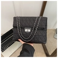 Detail einer schwarzen Stepptasche mit silberner Kette und Metall-Drehverschluss - Schwarz