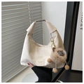 Detail of cream pleated leather bag with silver buckle and cute plush lamb pendant - With Pendant / Off White