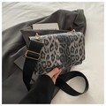 Detail of leopard print crossbody bag with wide strap on grey blazer for winter fashion - Black