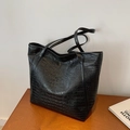 Black crocodile-pattern tote bag with large capacity for women shown on a wooden table - Black