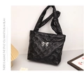 Dettaglio della borsa tote nera trapuntata con finitura satinata e fiocco decorativo in metallo - Nero