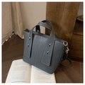 Detailed shot of dark grey tote with white stitching and gold hardware on wooden desk - Gray