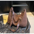 Detalle del bolso tote de ante marrón con costuras en contraste y correa de cuero ajustable - café