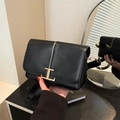 Sleek black leather crossbody bag featuring a golden T-shaped metal clasp and wide strap - Black
