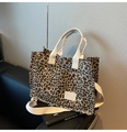 Borsa tote in tela leopardata con tracolla e doppie tasche su un divano nero - Cachi