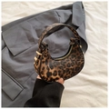 Detail of leopard print crescent bag with golden zipper on gray blazer background - Coffee
