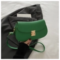 Bolso bandolera verde con textura de litchi y cierre metálico dorado sobre blazer negro - Verde