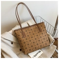 Nahaufnahme der braunen Vintage-Einkaufstasche mit Monogramm-Druck und Lederstruktur - Braun