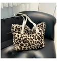 Leopard-Faux-Fur-Tote-Tasche mit weißen Ledergriffen auf einem schwarzen Ledersessel - Weiß