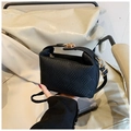 Close-up of black woven texture small crossbody bag with golden metal lock detail - Black