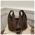 Detail of soft vintage brown leather tote bag with silver metal buckle on knit blanket - Brown
