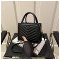 Detalle de bolso negro en cuero sintético con acolchado chevron y anillas doradas - Negro