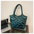 Gros plan du sac cabas matelassé vert foncé avec motif chevron et texture brillante - Vert
