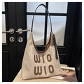 Close-up of beige canvas tote bag with brown WIO WIO lettering and leather piping detail - With Charm / Off White