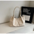 Detail of cream tote bag with vertical stitching and pleated texture on marble surface - Off White