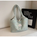 Detailed close-up of rainbow knit tote bag featuring soft macaron texture and metal snap button - Green