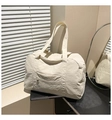 Detail of a large cream tote bag with natural crinkle texture and front zip pocket - White