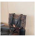 Detail of leopard print tote bag featuring black leather front pocket and gold rivets - Black