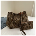 Dettaglio del set borsa tote leopardata con pochette coordinata su superficie bianca - Marrone