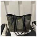 Dettaglio della borsa tote verde oliva con scritte dorate su una sedia in metallo - Nero Senza Ciondolo