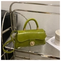 Detail of lime green faux leather handbag featuring a gold circular twist lock and handle - Green Without Pendant