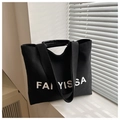 Black canvas tote bag featuring white FAI YISSA lettering and wide leather handles - Black
