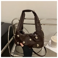 Detail der dunkelbraunen Lackledertasche mit silbernen Metallnieten und Falten-Design - Kaffeebraun