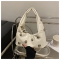 Detailansicht der elfenbeinfarbenen Falten-Cloud-Tasche mit großen silbernen Metallnieten - Weiß
