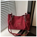Detalle del bolso tote burdeos de ante con cadena plateada y etiqueta de marca de moda - Rojo