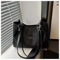 Detalle de un bolso shopper negro con correas de cadena plateada y parche de cuero - Negro