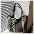 Detalle del bolso tote de lona a rayas con lazo decorativo de lunares y asas de cuero - Azul
