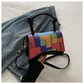 Detail of colorful geometric block pattern and black cylindrical handle on crossbody bag - Black
