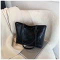 Detailansicht einer schwarzen gewebten Shopper-Tasche auf einem modernen Stuhl - Schwarz