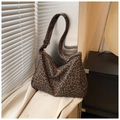 Borsa hobo leopardata con ampia tracolla e zip indossata su un trench beige elegante - Cachi