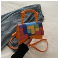 Détail macro du sac en cuir orange avec motif géométrique coloré et poignée nouée élégante - Orange
