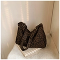 Dettaglio della trama leopardata e fibbia dorata su una borsa shopping capiente - caffè