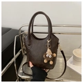 Dark brown leather bucket bag with plush charm and fashion brand embossed text - With Pendant Style / Brown