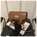 Detail view of brown oil-wax leather texture and white logo text on the stylish saddle bag - Brown