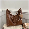 Detail of a large brown tote bag in oil wax leather with drawstring knot and gold eyelets - Brown with Pendant