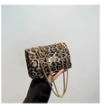 Dettaglio borsa leopardata con catena dorata e chiusura a rotazione in primo piano - Marrone