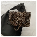 Chic leopard print crossbody bag with gold chain strap on a stylish white fabric background - Brown